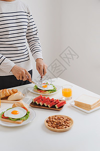 人手切鸡蛋在纸上 提供面包 草药 香肠和新鲜果汁熏肉早餐小吃白色胡椒沙拉食物盘子午餐绿色图片