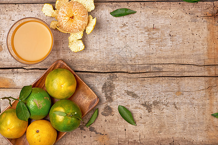 玻璃中的柑橘汁和木本底的新鲜番茄桔子热带黄色橙子饮料桌子早餐食物白色橘子饮食图片