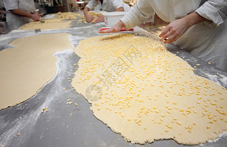 在面包店工厂做饼干时手工切分面纸 以制作饼干图片