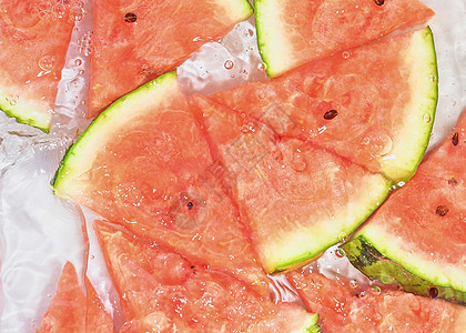 瓜片在白色背景的水中 带有气泡的液体中的甜瓜特写 红熟瓜片在水中 水果在水中的宏观形象种子食物西瓜饮食晴天飞溅野餐生产果皮收成图片
