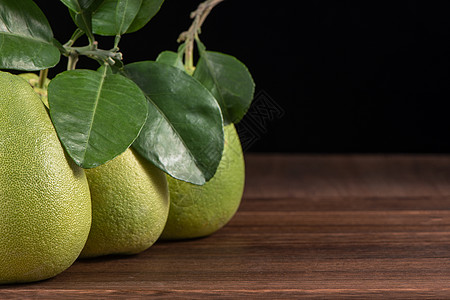 深黑木木板桌上有绿叶子的果实 在中秋节附近的季节性水果 闭合 复制空间 包括饮食叶子木头皮肤桌子节日食物树叶柚子图片