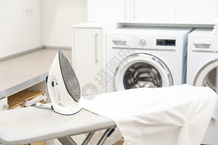 洗衣房用白衬衫和铁烫衣板杂物器具衬衫织物熨烫洗涤洗衣家庭作业工作发电机图片