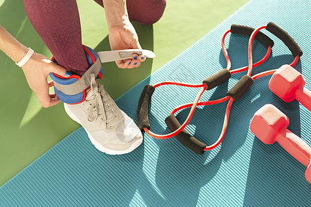 妇女在健身 健康和健身概念中开始锻炼前 先戴脚踝护身衣体操运动装健身房运动理疗配重娱乐袖口配饰活动图片