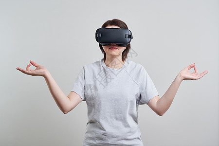 快乐的年轻女人在室内玩 VR 眼镜虚拟现实概念与年轻女孩玩耳机护目镜和复制空间乐趣模拟女性电子模拟器游戏工具女士视频展示图片