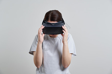 快乐的年轻女人在室内玩 VR 眼镜虚拟现实概念与年轻女孩玩耳机护目镜和复制空间游戏电子微笑展示模拟娱乐女性女士乐趣视频图片