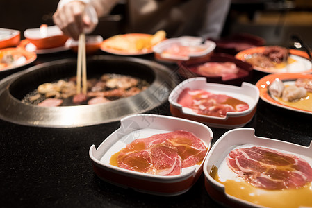 日式自助餐烧烤烤烤烤炉上的生牛肉和猪肉片或日式八金背景