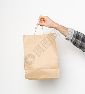 男性手用格子衬衣 折袖手持棕色纸袋 在白色背景上被孤立 交付概念 外送食品纸袋销售工艺回收生态食物包装嘲笑市场礼物环境图片