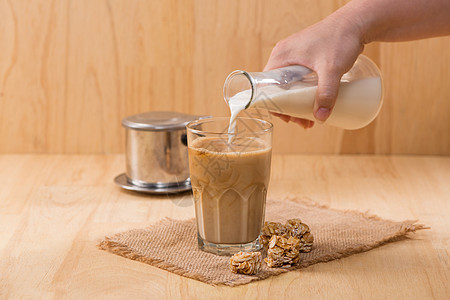 将牛奶倒在木制桌上的咖啡杯上酸奶白色食物液体玻璃杯子粉色桌子奶制品奶油图片