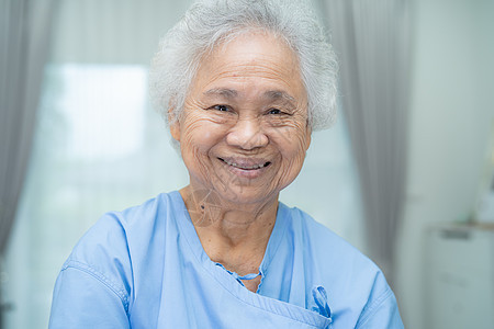 亚洲老年或老年老妇人患者坐在护理医院病房的床上时笑容灿烂 健康强健的医疗理念图片