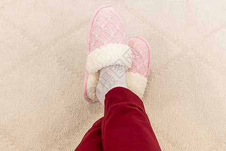 穿着粉红色编织拖鞋的交叉腿卧室小地毯地面女孩粉色女士红色羊毛纺织品鞋类图片