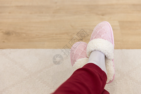 穿着粉红色编织拖鞋的交叉腿女孩女士鞋类小地毯羊毛地面粉色裤子纺织品红色图片