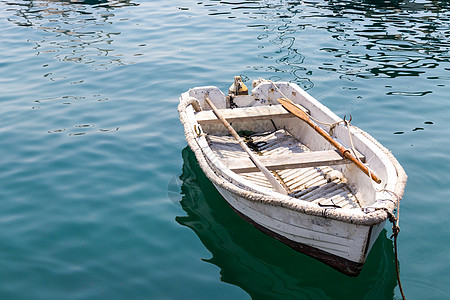 湖中蓝蓝色平静水的白木小白木船孤独闲暇木头运输海洋活动白色旅行钓鱼图片