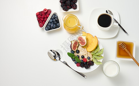 一杯黑咖啡 一盘燕麦和水果 蜂蜜和白桌子上一杯牛奶 一份健康的早早餐图片