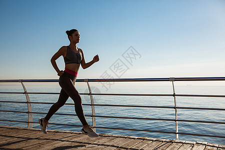 女运动员在海边赛车场锻炼和慢跑的一面观景 她正在码头上运动行动天空海洋女性慢跑者福利成人女孩阳光码头图片
