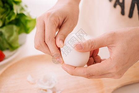 女性的手正在剥鸡蛋 女人在家准备早餐 在深色桌子上的木器中煮鸡蛋 复古色调蛋壳成人营养黄色女孩食物白色女士烹饪背景图片