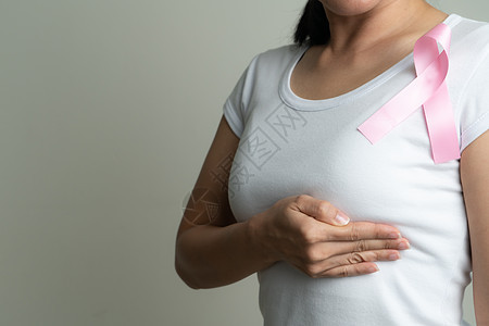 支持乳腺癌病因的胸口妇女胸上粉红色徽章丝带 乳癌认识概念治愈活动肿瘤学机构幸存者癌症治疗手术胸部女士图片