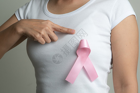 支持乳腺癌病因的胸口妇女胸上粉红色徽章丝带 乳癌认识概念治疗药品帮助胸部机构外科预防幸存者女士保健图片