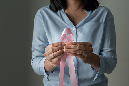 妇女手上的粉红色徽章丝带 以支持乳腺癌的原因乳癌认识概念活动女士胸部治愈女孩药品肿瘤学帮助志愿者卫生图片