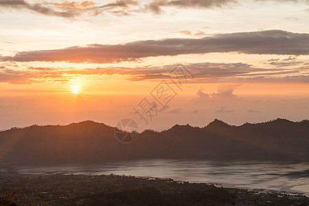 巴图尔湖上日出木头首脑太阳顶峰远景火山天空反射旅行树叶图片