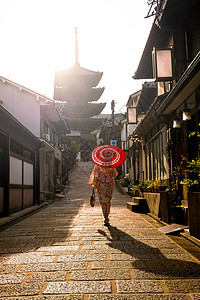 在京都老城 红伞横田的日本女孩女士浴衣街道建筑学地标传统地区建筑宝塔文化背景图片