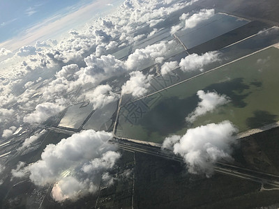 飞机窗口俯视着许多云层和农田高清图片