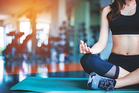 在健身房的垫子上做瑜伽的女人 运动和锻炼的概念 冥想和健身主题 手上的选择性焦点图片