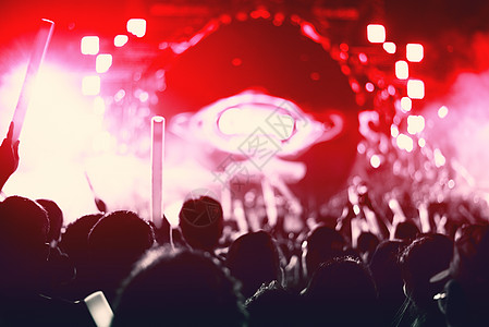 摇滚音乐会与剪影人在快乐的姿态和举起手来振作起来的歌手 娱乐和人的概念 歌手和观众主题 红调图片