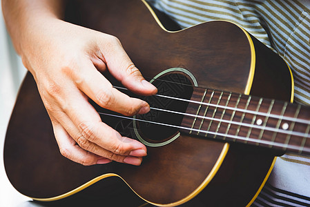 弹吉他的吉他手手特写镜头 乐器的概念 户外和休闲主题 在左手上的选择性焦点 复古乡村民谣吉他与音乐歌手 特写了艺人的手乐队娱乐玩背景