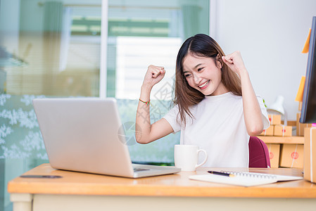 亚洲女性在办公室使用笔记本电脑和互联网时很享受 商业和营销以及兼职概念 网上购物和商业成功的主题 完成工作时心情愉快图片