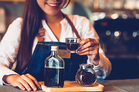 咖啡杯的特写镜头与美丽的亚洲女性咖啡师背景 用于制作咖啡为顾客服务 工作和职业 食物和饮料 咖啡店和咖啡馆 商业和餐厅服务员瓶子图片