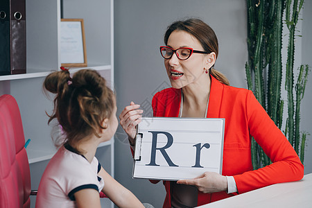 语音能力问题口语课程概念 语言治疗师教女孩说字母 R 女性语言治疗师教学龄前儿童发音图片