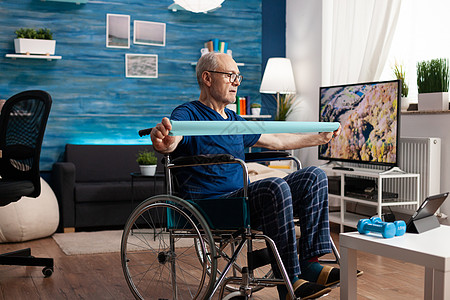 残疾老人在轮轮椅训练中接受手臂抵抗力锻体肌肉训练残障药片事故反抗老年有氧运动课程视频人士退休图片