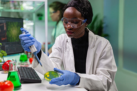 从试管中提取基因溶液的生物学家科学家非洲女研究员玻璃电脑实验测试科学生长团体植物学生物农业图片