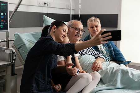 利用现代智能手机照顾家庭 与生病的年老爷爷一起自拍孙女外科微笑病人药品访问祖父母退休诊所手术图片
