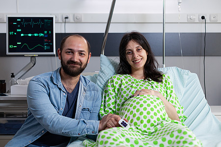 期待在医院病房中怀着微笑的一对夫妇送货产妇丈夫怀孕诊所母亲母性女士腹部夫妻图片