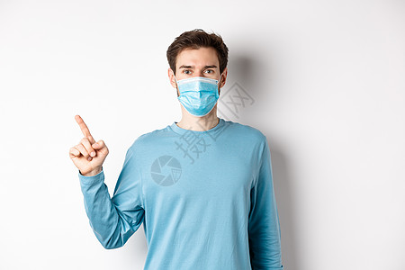 Corona病毒 健康和检疫概念 穿医疗面具的白人男子用左手指向左 显示徽标 穿着白底散衣站立口罩办公室商业社交肺炎成功生活男人图片