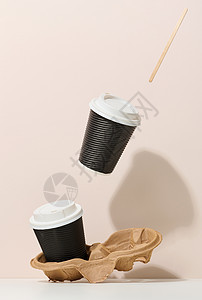 2个棕色纸板杯 有白色塑料盖 可用餐具悬浮在蜜蜂背景上图片