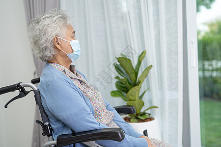 坐在轮椅上的老年妇女向窗外看望等待着某人 可悲 忧郁和沮丧的悲哀病人老太婆厨房女士麻痹人员退休窗户卫生疗养院图片