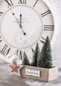 圣诞钟和冬季装饰 新年快乐概念古董装饰品新年松树问候卡片蓝色手表时间问候语背景图片