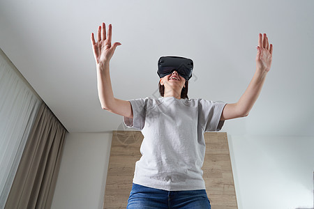 快乐的年轻女人在室内玩 VR 眼镜虚拟现实概念与年轻女孩玩耳机护目镜和复制空间模拟电子展示成人视频模拟器女性微笑游戏乐趣图片