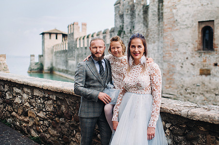 一个快乐的年轻家庭走过意大利老城Sirmione 在意大利的时尚家庭散步女儿正方形女孩女士建筑物照片男人幸福古董父母图片