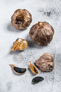 整个气压发酵的黑大蒜 白色背景 顶部视图蔬菜芳香美味熏制黑蒜食物桌子灯泡营养草本植物图片