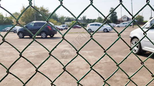 在网栅栏后面的汽车 安全 有人看守的停车场 罚款 逮捕概念城市天空街道金属车辆内衬运输车库绿色公园图片