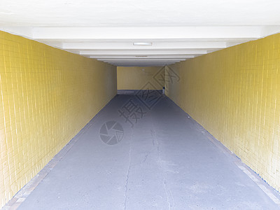 党政边框带通道空的黄色地下人行横道 隧道和尽头的日光 在人行横道处走到顶部 城市地下有一条带灯笼的长混凝土隧道入口过境行人街道通道建筑旅行楼梯背景