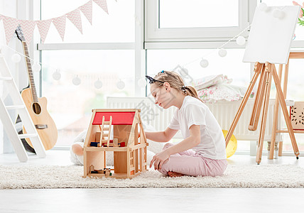 漂亮的小女孩玩玩洋娃娃屋房间公寓小学生女学生喜悦房子玩具快乐娃娃庆典图片