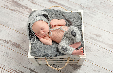 睡在灰色内裤和有兔子耳朵的帽子上正方形皮肤孩子毯子童年新生婴儿襁褓野兔睡眠图片