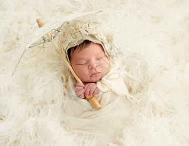 使用装饰伞睡觉的新生儿婴儿背景图片