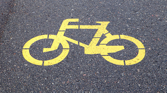 代表自行车路径的自行车符号 自行车在柏油路上涂成黄色的标志 平躺 顶视图车辆路标安全交通车道道路途径公园沥青路面图片