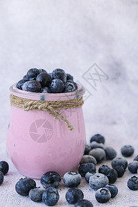 桌上放着酸奶和蓝莓的碗 蓝莓酸奶配新鲜蓝莓 健康的早餐 超级食物健康吃素食素食奶制品勺子小吃水果玻璃饮食排毒乳制品美食烹饪图片