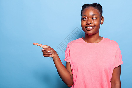 微笑的非洲女青年向左指着手指的肖像图片